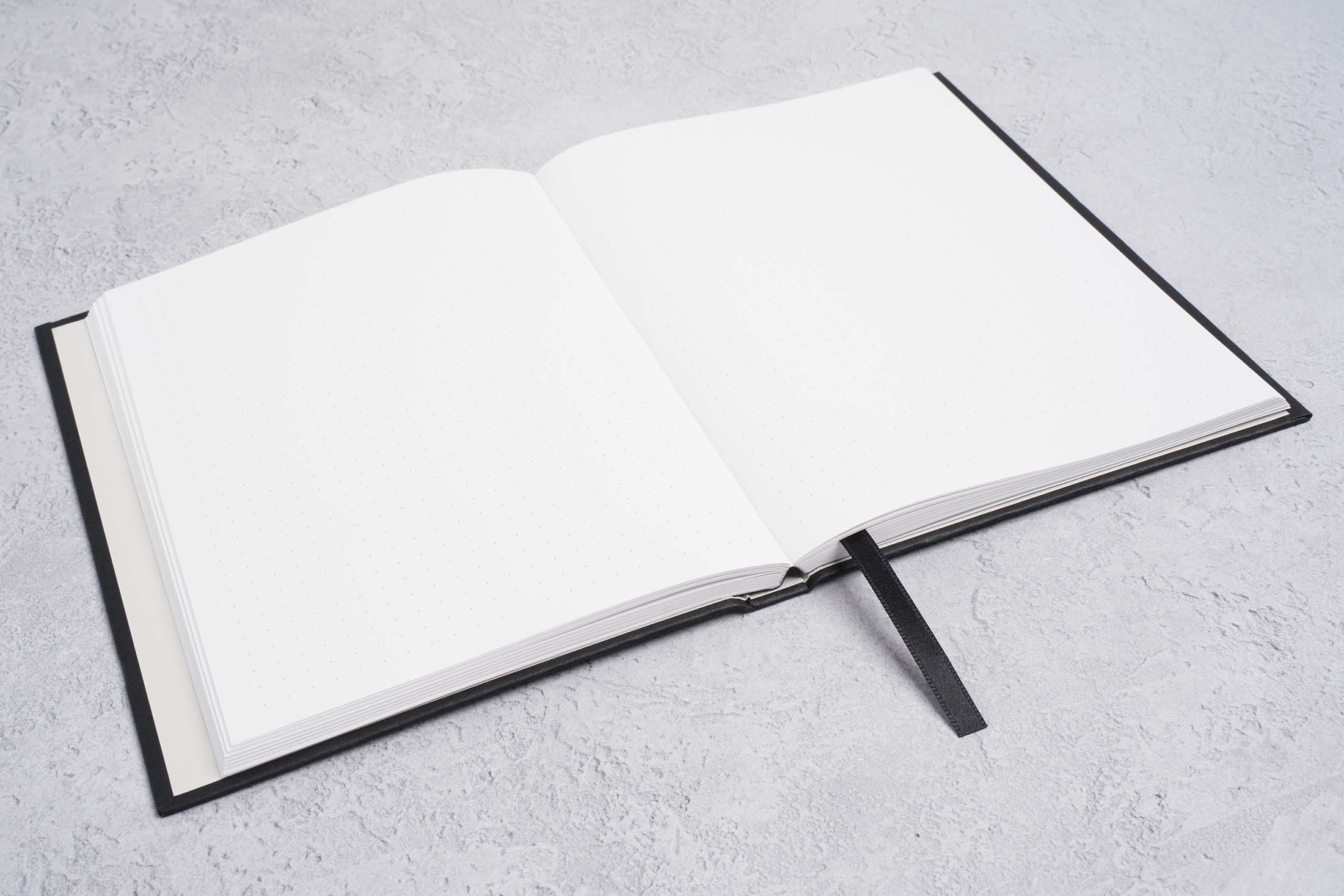 the paper mind blocker paper hardcover notebook open on a flat surface. the notebook lays flat showing the Gmund blocker paper sheets
