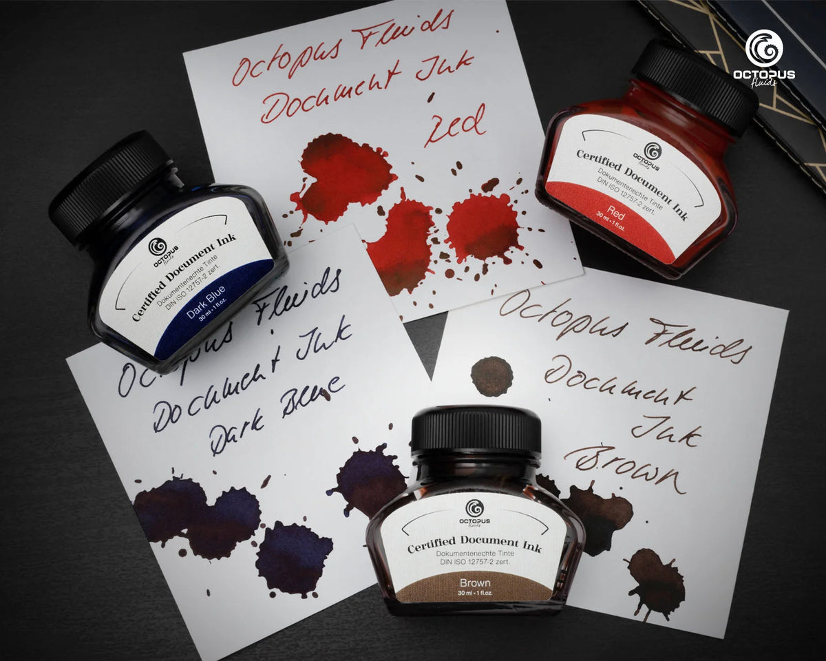 Three bottles of Octopus Fluids Document Ink with ink splashes on paper.