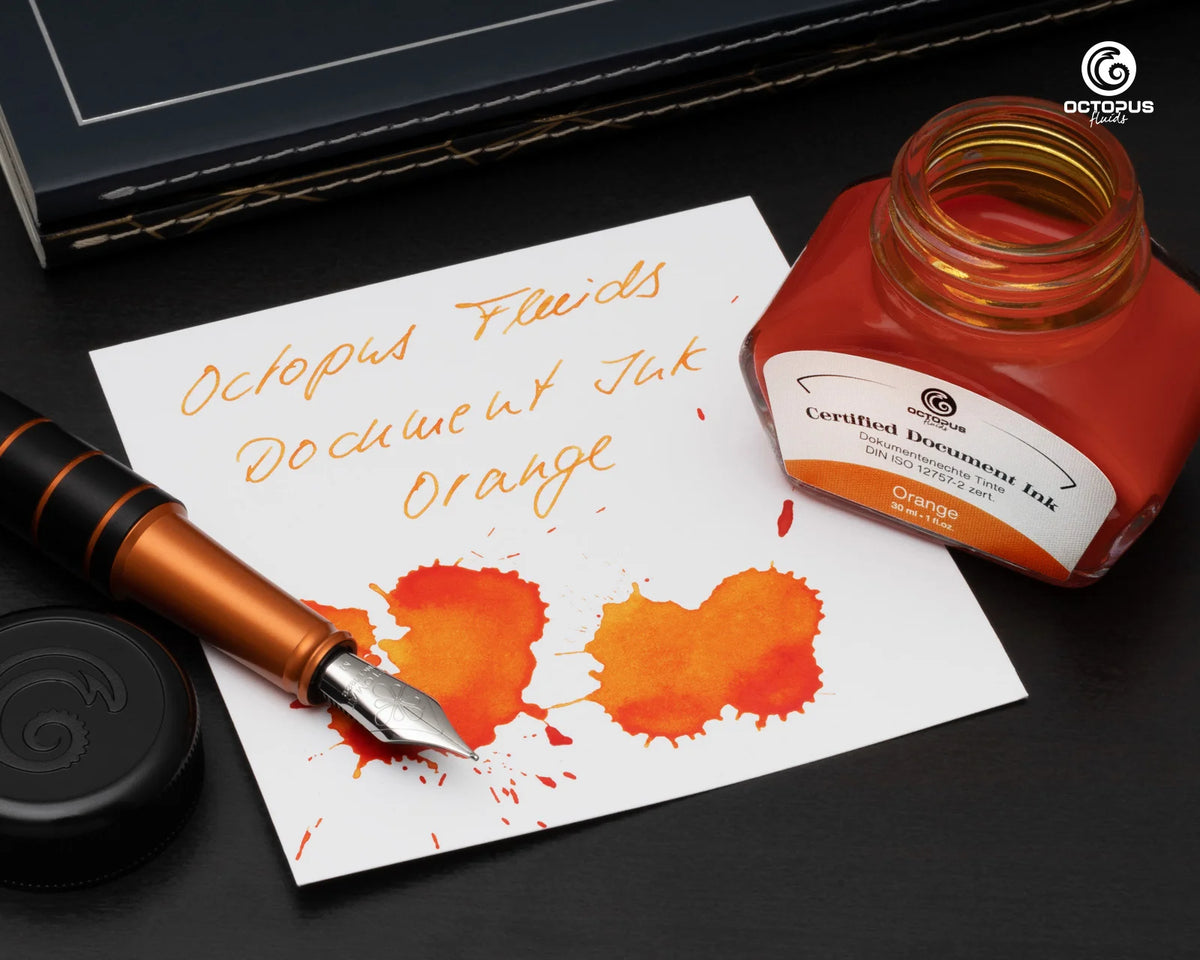 Orange ink bottle and fountain pen on a piece of paper with ink splashes, branded 'Octopus'. Octopus Fluids Fountain Pen Document Ink - 30 ml Bottle - Orange -  Made in Germany